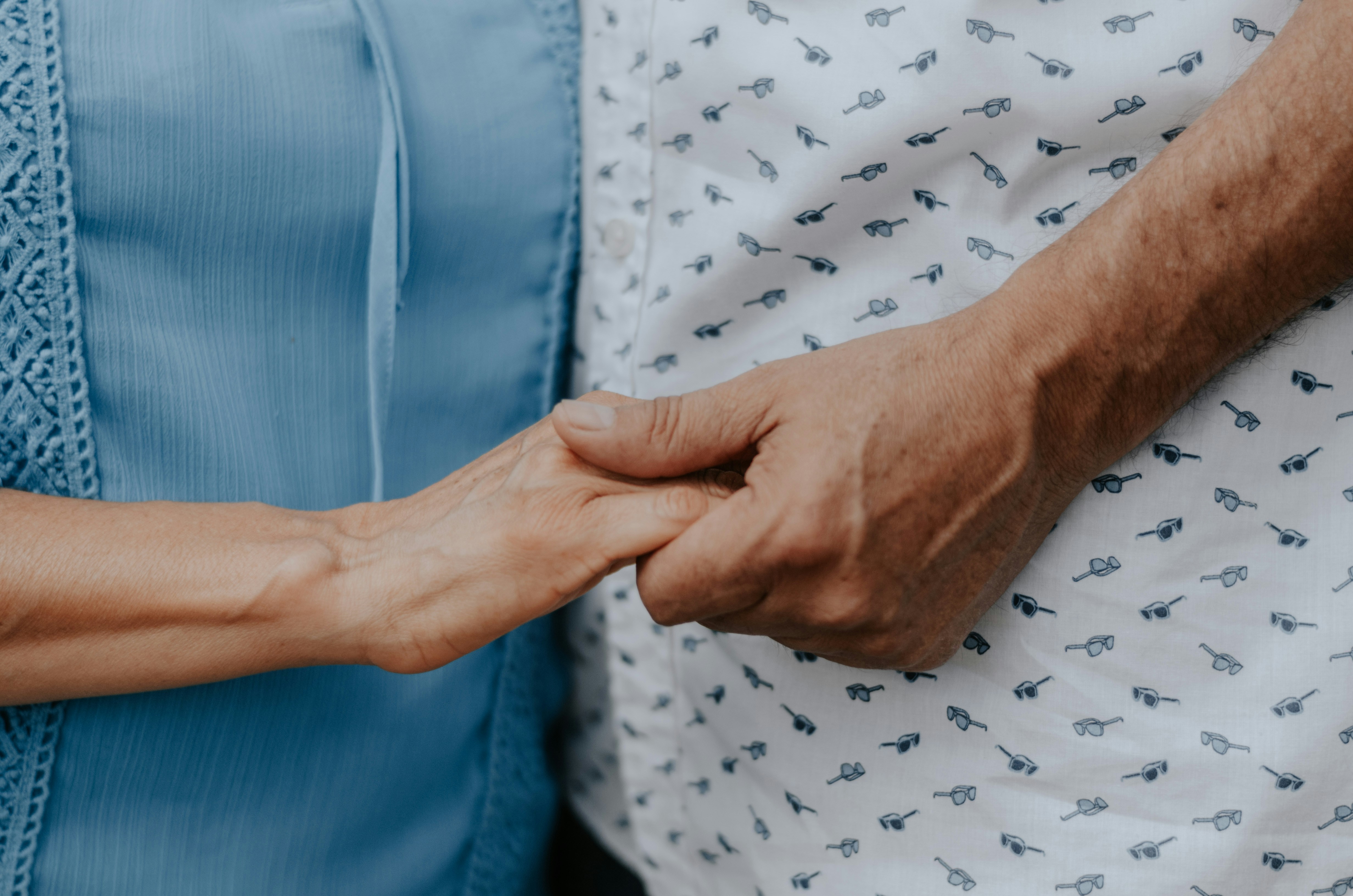 A patient and a family member holding hands
